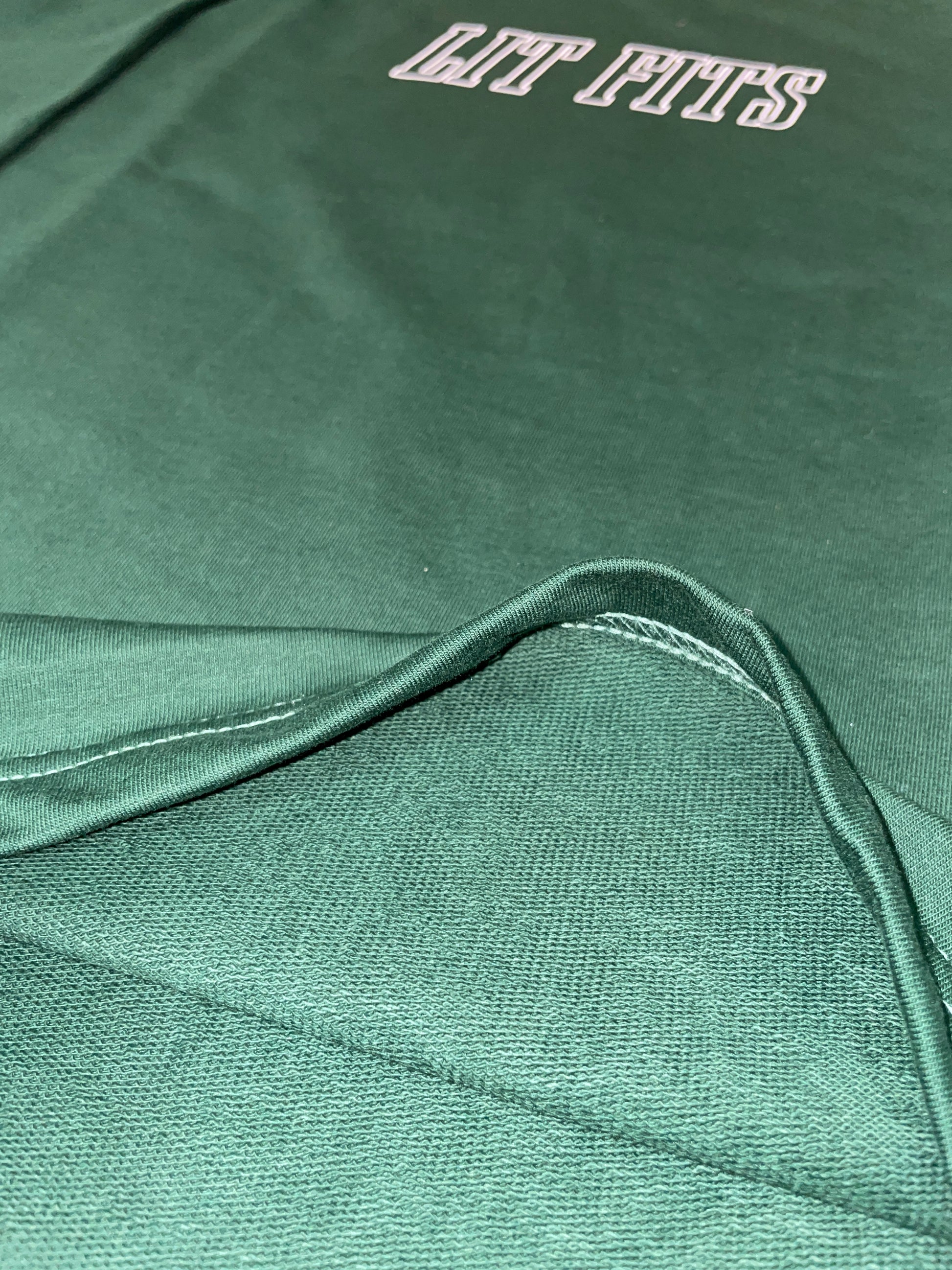 Close-up of green oversized t-shirt showcasing premium 240 gsm cotton and HD print design, emphasizing the relaxed fit.