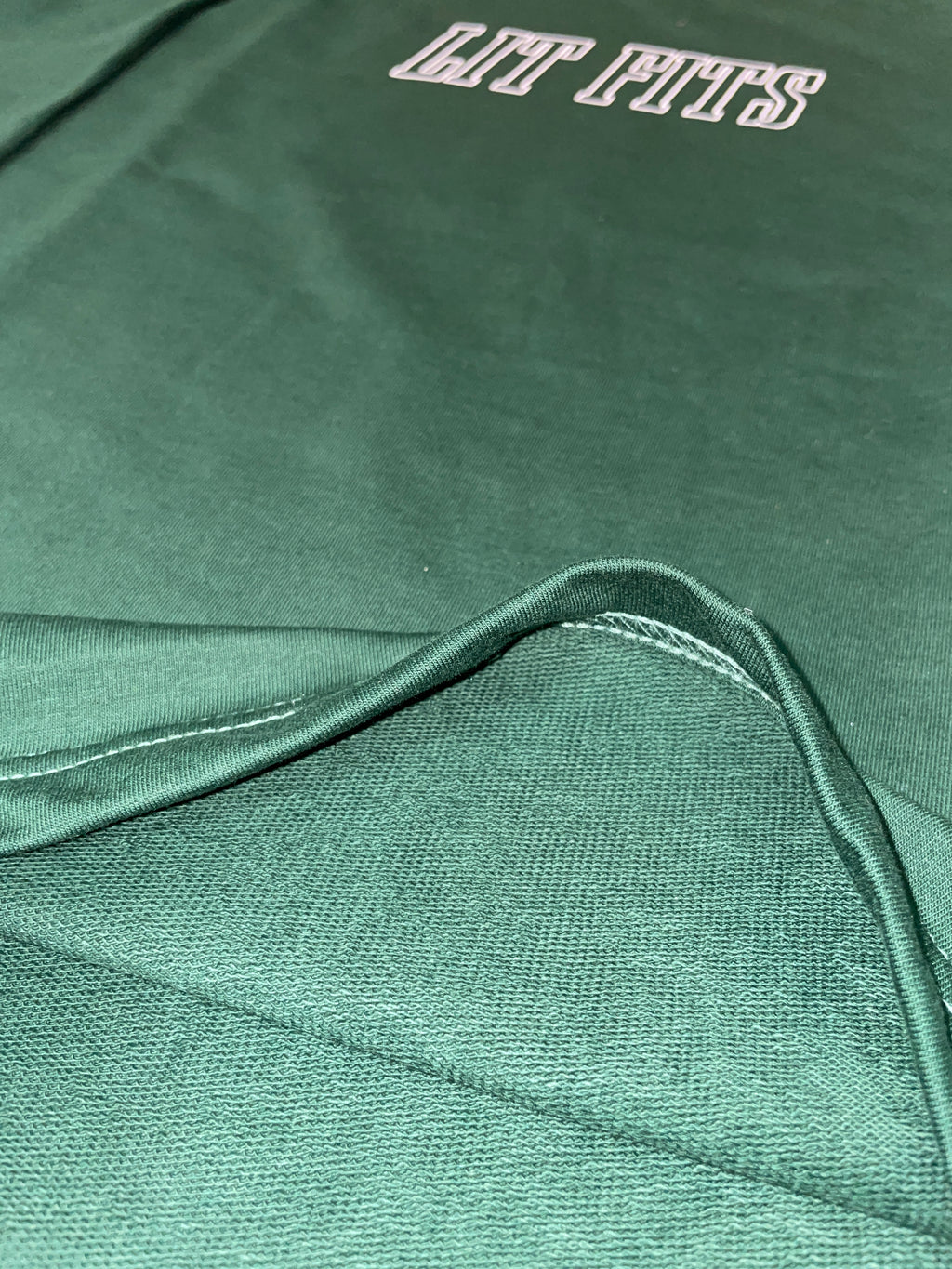 Close-up of green oversized t-shirt showcasing premium 240 gsm cotton and HD print design, emphasizing the relaxed fit.